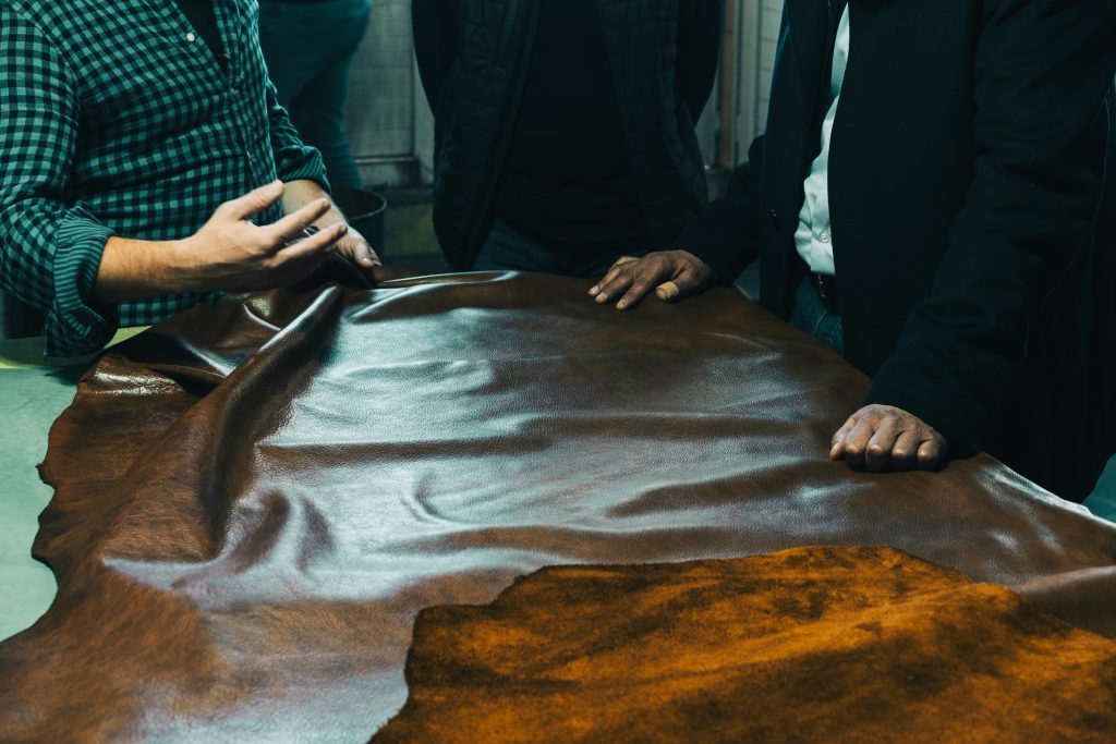 A group of craftsmen examining leather on a table in Gerede, Bolu, Türkiye.